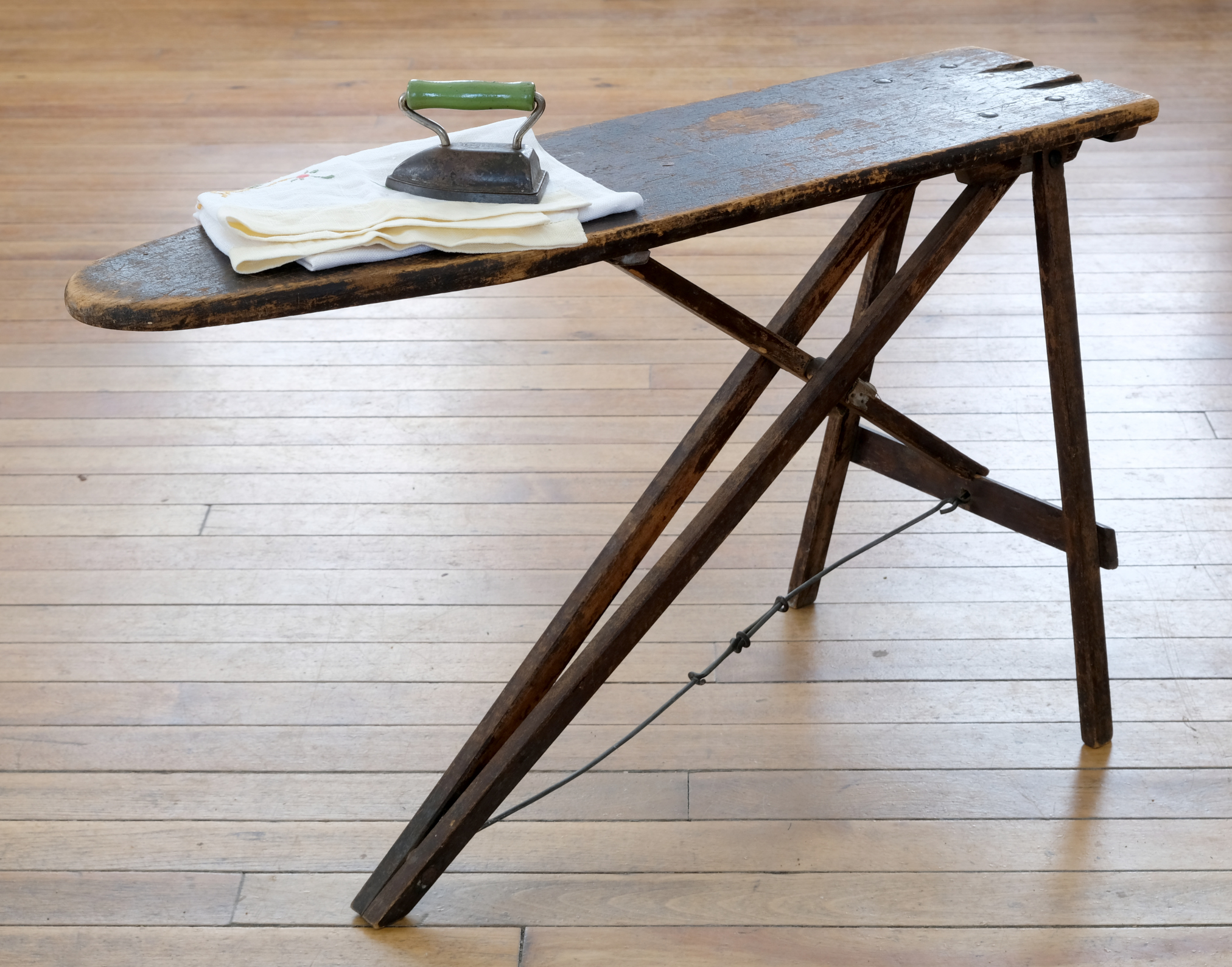 The Museum's child's ironing board with a mini iron and cloth on top