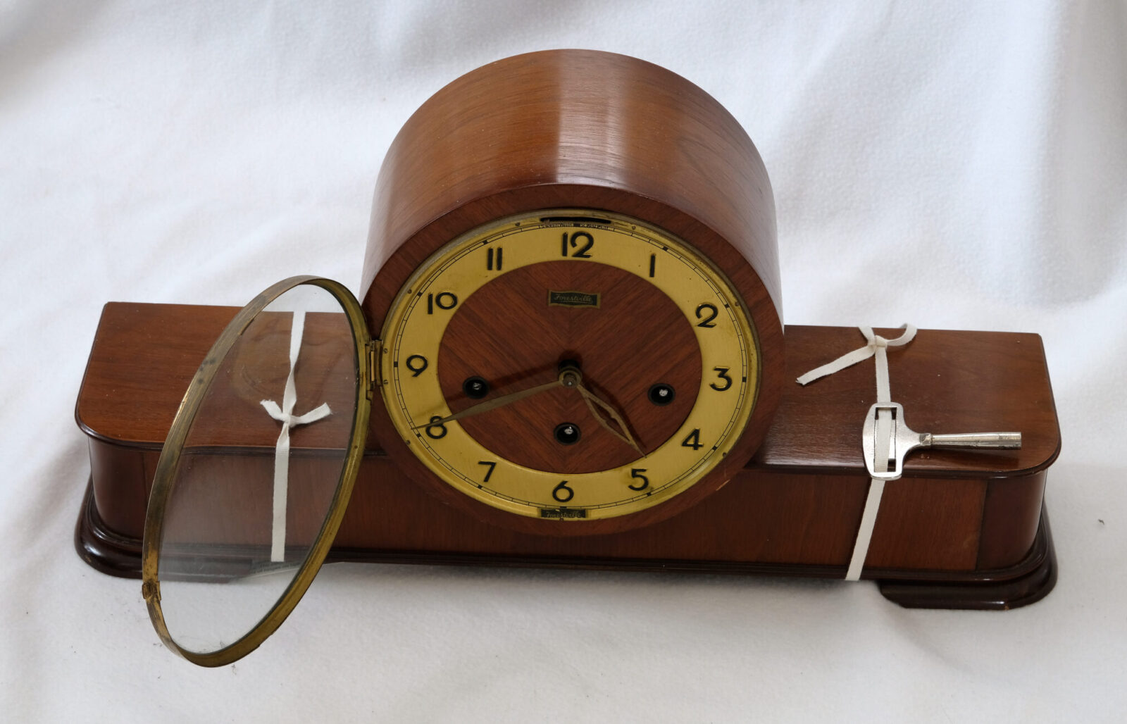 Vintage wooden mantel clock with glass cover.